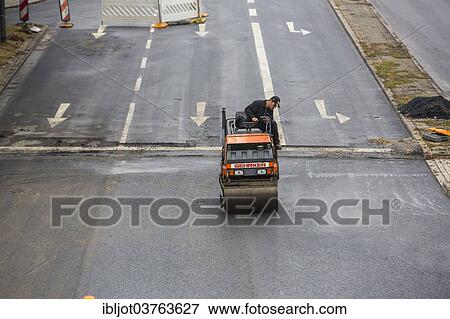 "Roller compactor, tarmac laying works at a large inner-city road construction site, Essen, North Rhine-Westphalia, Germany, Europe" View Large Photo Image Stock Photo - "Roller compactor, tarmac laying works at a large inner-city road construction site, Essen, North Rhine-Westphalia, Germany, Europe". Fotosearch