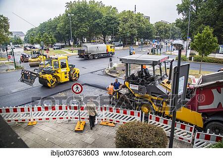 "Rolling machines and an asphalt spreader during asphalt work on a large urban road construction site, Essen, North Rhine-Westphalia, Germany, Europe" View Large Photo Image Stock Image - "Rolling machines and an asphalt spreader during asphalt work on a large urban road construction site, Essen, North Rhine-Westphalia, Germany, Europe". Fotosearch
