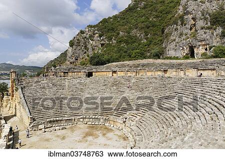 "Roman Theatre, necropolis or city of the dead, ancient Lycian rock tombs at back, Myra, Demre, Lycia, Province of Antalya, Turkey, Asia" View Large Photo Image Stock Image - "Roman Theatre, necropolis or city of the dead, ancient Lycian rock tombs at back, Myra, Demre, Lycia, Province of Antalya, Turkey, Asia". Fotosearch