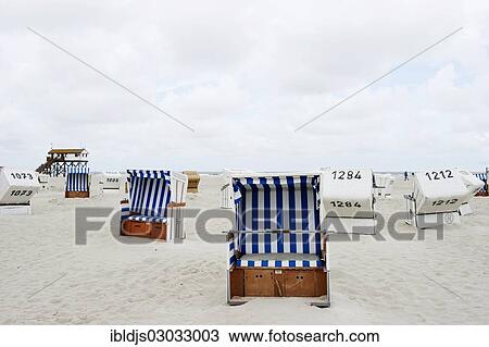 "Roofed wicker beach chairs on the beach in front of a house on stilts, St Peter-Ording, Schleswig-Holstein, Germany, Europe" View Large Photo Image Stock Image - "Roofed wicker beach chairs on the beach in front of a house on stilts, St Peter-Ording, Schleswig-Holstein, Germany, Europe". Fotosearch