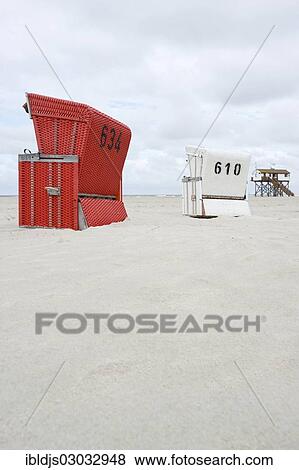 Stock Photo - "Roofed wicker beach chairs on the beach in front of a house on stilts, St Peter-Ording, Schleswig-Holstein, Germany, Europe". Fotosearch
