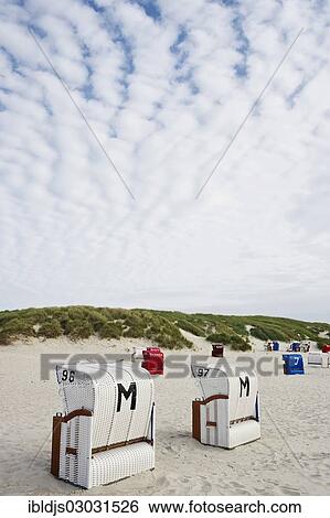 "Roofed wicker beach chairs on the beach in front of sand dunes, Norddorf, Amrum, Amrum, North Frisian Islands, Schleswig-Holstein, Germany, Europe" View Large Photo Image Stock Photograph - "Roofed wicker beach chairs on the beach in front of sand dunes, Norddorf, Amrum, Amrum, North Frisian Islands, Schleswig-Holstein, Germany, Europe". Fotosearch