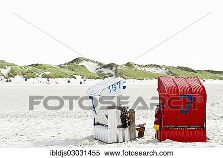 Stock Photography - "Roofed wicker beach chairs on the beach in front of sand dunes, Norddorf, Amrum, Amrum, North Frisian Islands, Schleswig-Holstein, Germany, Europe". Fotosearch