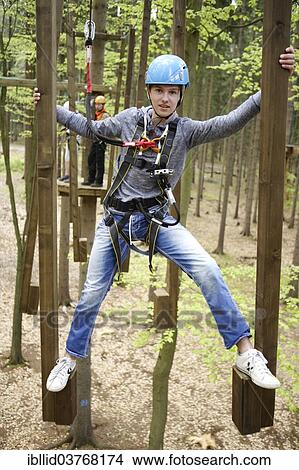 Picture - "Roped up boy climbing in a climbing park, Karlovy Vary Region, Bohemia, Czech Republic, Europe". Fotosearch