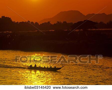Stock Image - "Ruea Hang Yao or long tail boat, speedboat on the Kok River, at sunset, Chiang Rai, Chiang Rai Province, Northern Thailand, Thailand, Asia". Fotosearch