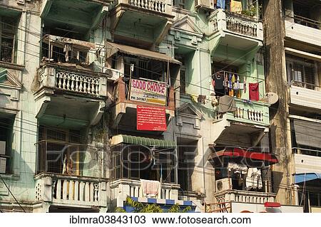 Stock Image - "Run-down townhouses with real estate advertising, Yangon, Myanmar, Asia". Fotosearch