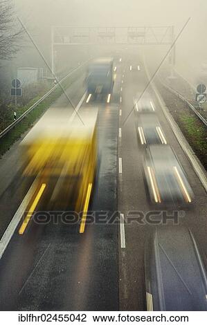 Stock Image - "Rush hour on a motorway with early morning fog, Grevenbroich, North Rhine-Westphalia, Germany, Europe". Fotosearch