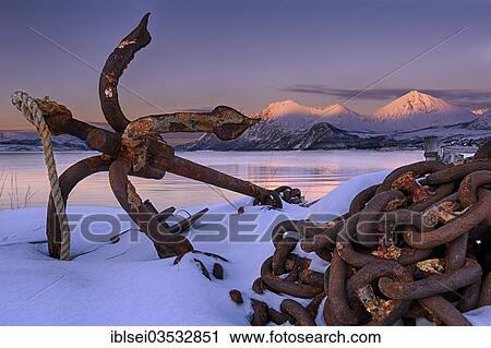 "Rusty anchor in front of a fjord with a mountain range in the evening light, Tromso, ‪Troms, Northern Norway, Norway, Europe" View Large Photo Image Stock Image - "Rusty anchor in front of a fjord with a mountain range in the evening light, Tromso, ‪Troms, Northern Norway, Norway, Europe". Fotosearch