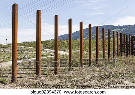 Stock Image - "Rusty steel poles for flood protection at the hydroelectric power plant in Malters, Lucerne, Switzerland, Europe". Fotosearch