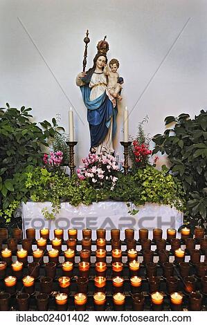 "Sacrificial candles and a statue of Mary wearing a crown holding baby Jesus, Schaeftlarn Abbey, Schaeftlarn, Bavaria, Germany, Europe" View Large Photo Image Stock Image - "Sacrificial candles and a statue of Mary wearing a crown holding baby Jesus, Schaeftlarn Abbey, Schaeftlarn, Bavaria, Germany, Europe". Fotosearch