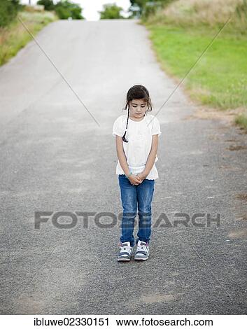Sad little girl standing on a path View Large Photo Image Stock Image - Sad little girl standing on a path. Fotosearch