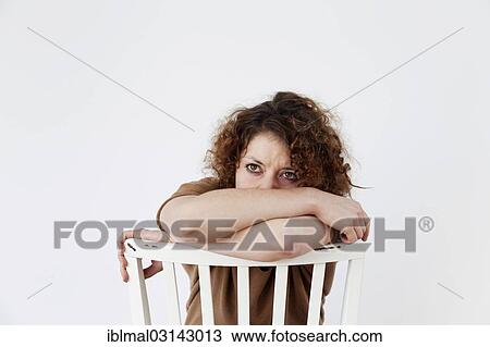 Sad young woman sitting on a chair View Large Photo Image Stock Image - Sad young woman sitting on a chair. Fotosearch