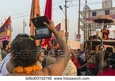 Stock Photograph - "Sadhu, holy man, taking pictures at the Shahi Snan, the royal bath, during Kumbha Mela festival, Allahabad, Uttar Pradesh, India, Asia". Fotosearch