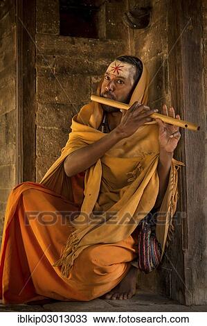 Stock Image - "Sadhu playing a flute, Pashupatinath, Kathmandu, Kathmandu District, Bagmati Zone, Nepal, Asia". Fotosearch