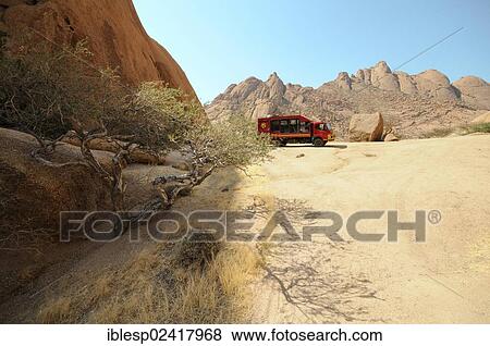 Safari truck, savannah landscape with granite rocks and Spitzkoppe Mountain, Pontok Mountains, Grosse Spitzkuppe Nature Reserve, Namibia, Africa View Large Photo Image Stock Photo - Safari truck, savannah landscape with granite rocks and Spitzkoppe Mountain, Pontok Mountains, Grosse Spitzkuppe Nature Reserve, Namibia, Africa. Fotosearch