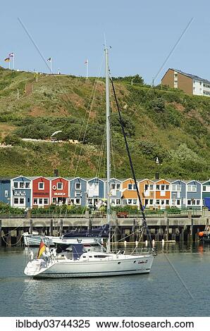 Stock Photography - "Sailing ship in the harbour of Heligoland or Helgoland in front of Hummerbuden or lobster shacks, Helgoland, Schleswig-Holstein, Germany, Europe". Fotosearch