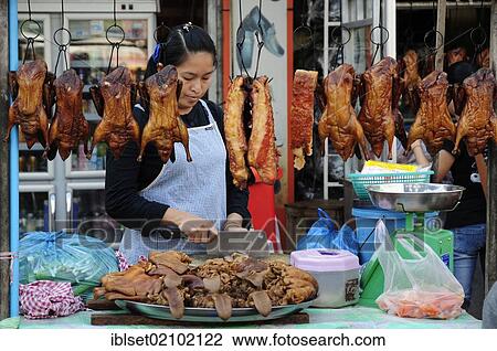 Stock Image - "Saleswoman at a stall with meat, chicken, tongue, Cambodia, Southeast Asia, Asia". Fotosearch