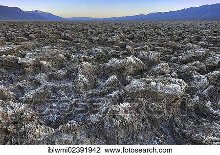Stock Image - "Salt crusts at the Devil's Golf Course at sunset, Panamint Range, Death Valley National Park, Mojave Desert, California, USA". Fotosearch