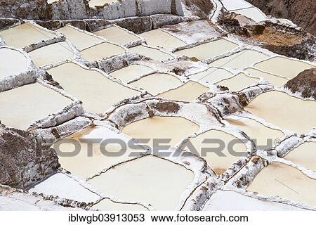 Stock Image - "Salt pans on a mountainside, Salinas de Maras salt pans, created by the Incas and still in operation, Pichingote, Cusco region, Andes, Peru, South America". Fotosearch