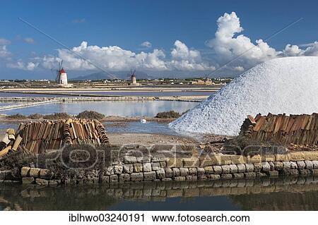 "Salt stockpile, water basin and channel, windmills at, salt harvest in the Salinas, bei Trapani, Sicily, Italy, Europe" View Large Photo Image Stock Image - "Salt stockpile, water basin and channel, windmills at, salt harvest in the Salinas, bei Trapani, Sicily, Italy, Europe". Fotosearch