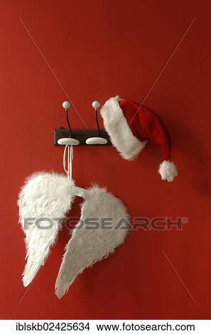 Santa hat and angel wings hanging on nostalgic coat hooks View Large Photo Image Picture - Santa hat and angel wings hanging on nostalgic coat hooks. Fotosearch