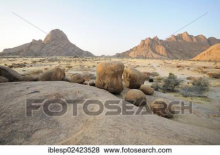 Stock Photo - Savannah landscape at sunset with rock formations, Great Spitzkoppe and Pontok Mountains, Great Spitzkoppe Nature Reserve, Namibia, Africa. Fotosearch