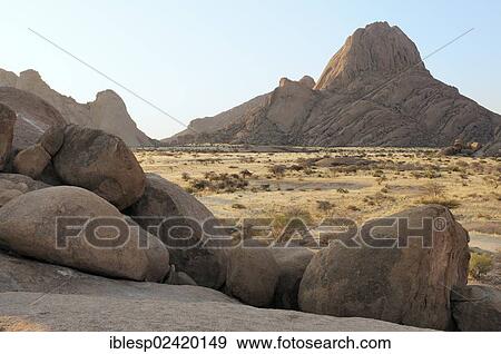 Stock Photo - Savannah landscape with rock formations, Great Spitzkoppe Mountain and Pontok Mountains, Spitzkoppe, Grosse Spitzkuppe Nature Reserve, Namibia, Africa. Fotosearch