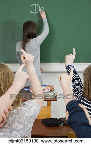 "School children putting up their hands to answer in a classroom, Germany, Europe" View Large Photo Image Stock Photo - "School children putting up their hands to answer in a classroom, Germany, Europe". Fotosearch