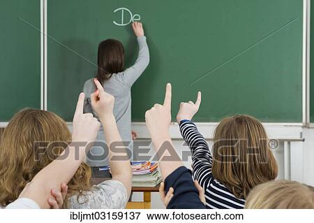 "School children raising their arms to answer during class, Germany, Europe" View Large Photo Image Stock Photo - "School children raising their arms to answer during class, Germany, Europe". Fotosearch