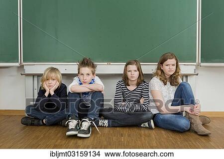 "School children sitting bored in the classroom on the floor in front of the blackboard, Germany, Europe" View Large Photo Image Picture - "School children sitting bored in the classroom on the floor in front of the blackboard, Germany, Europe". Fotosearch
