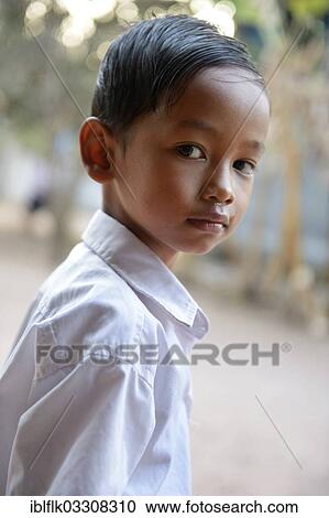 Stock Image - "Schoolboy with his combed hair back, wearing a white shirt, portrait, Lompong Village, Bathi District, Takeo Province, Cambodia, Asia". Fotosearch