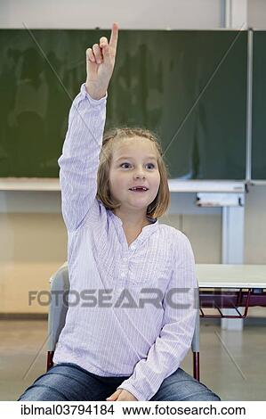 "Schoolgirl, 7 years, putting up her hands in the classroom" View Large Photo Image Picture - "Schoolgirl, 7 years, putting up her hands in the classroom". Fotosearch