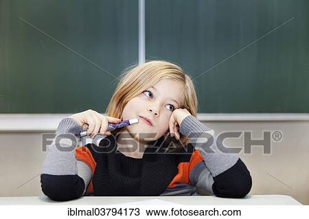 "Schoolgirl, 9 years, pensive, sitting in front of a blackboard" View Large Photo Image Stock Image - "Schoolgirl, 9 years, pensive, sitting in front of a blackboard". Fotosearch