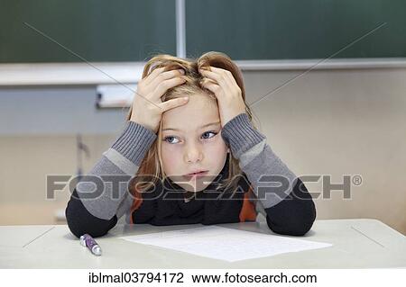 Stock Image - "Schoolgirl, 9 years, struggling during a difficult exam". Fotosearch