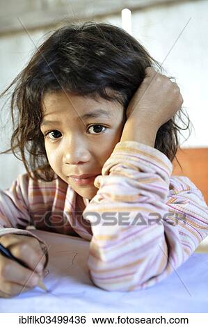 Stock Photograph - "Schoolgirl writing in a notebook, in the community of Mbya-Guarani Indians, Campito, Caaguazu Department, Paraguay, South America". Fotosearch