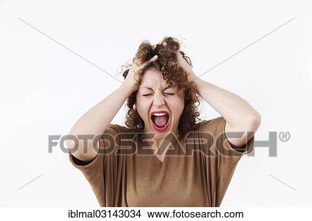 Picture - Screaming young woman tearing at her hair. Fotosearch