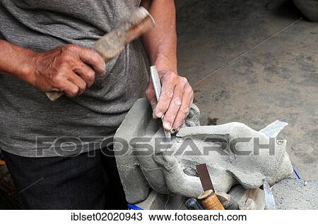 Stock Image - "Sculptor working on a Ganesha statue in Phnom Penh, Cambodia, Asia". Fotosearch