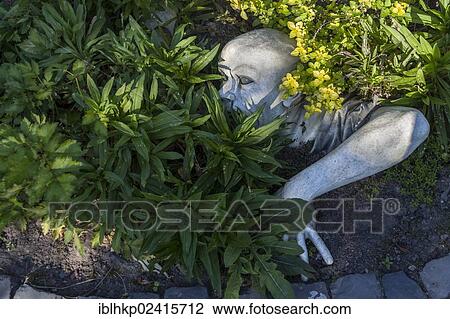 Sculpture in a garden, man digging himself out of the ground View Large Photo Image Stock Image - Sculpture in a garden, man digging himself out of the ground. Fotosearch