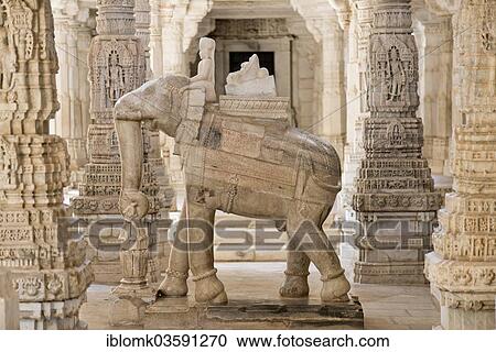 Stock Image - "Sculpture, man riding an elephant, between ornate pillars, marble temple, temple of the Jain religion, Adinatha Temple, Ranakpur, Rajasthan, India, Asia". Fotosearch