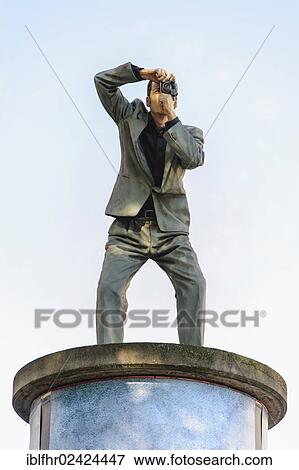 Sculpture of a man taking a photograph standing on an advertising column, Dusseldorf, North Rhine-Westphalia, Germany, Europe View Large Photo Image Stock Photo - Sculpture of a man taking a photograph standing on an advertising column, Dusseldorf, North Rhine-Westphalia, Germany, Europe. Fotosearch