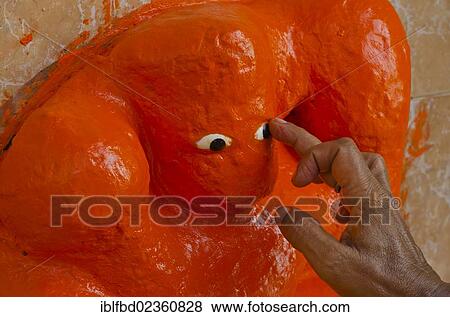 "Sculpture of God Ganesha getting freshly painted with orange paint, Varanasi, India, Asia" View Large Photo Image Stock Photo - "Sculpture of God Ganesha getting freshly painted with orange paint, Varanasi, India, Asia". Fotosearch