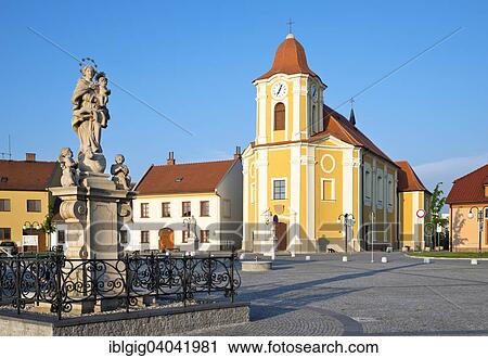 Stock Image - "Sculpture of Our Lady with the Child Jesus and church of St. Bartholomew, Veseli nad Moravou, Hodonin district, Jihomoravsky county, Czech Republic, Europe". Fotosearch