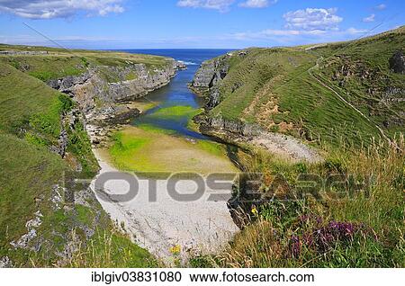 Stock Image - "Sea inlet with a trail to a viewpoint at Smoo Cave, Durness, Caithness, Sutherland and Easter Ross, Scotland, United Kingdom, Europe". Fotosearch