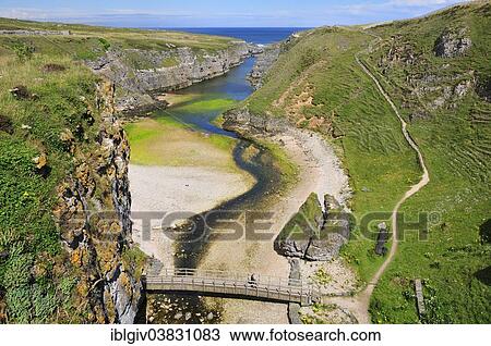 Stock Image - "Sea inlet with a trail to a viewpoint at Smoo Cave, Durness, Caithness, Sutherland and Easter Ross, Scotland, United Kingdom, Europe". Fotosearch