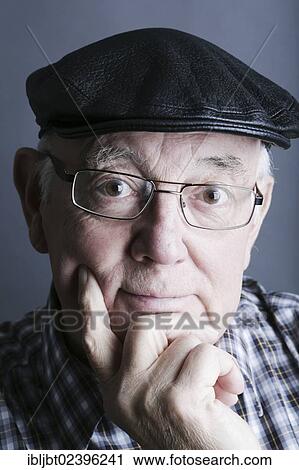 Stock Image - "Senior citizen, elderly man, with a cap and glasses, portrait". Fotosearch