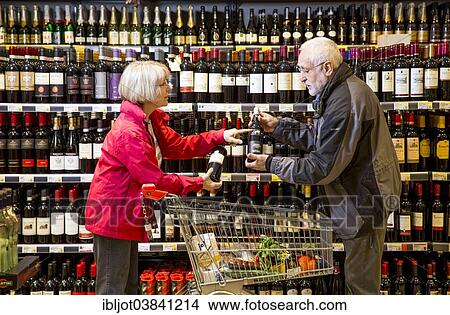 Picture - "Senior couple shopping in the wine department in a supermarket, Germany, Europe". Fotosearch