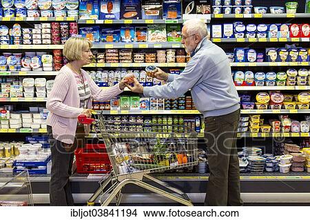 "Senior couple shopping with a shopping trolley in the refrigerated dairy section in a supermarket, Germany, Europe" View Large Photo Image Picture - "Senior couple shopping with a shopping trolley in the refrigerated dairy section in a supermarket, Germany, Europe". Fotosearch