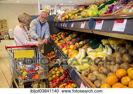 "Senior couple shopping with a shopping trolley in the fruit and vegetables department of a supermarket, Germany, Europe" View Large Photo Image Stock Image - "Senior couple shopping with a shopping trolley in the fruit and vegetables department of a supermarket, Germany, Europe". Fotosearch
