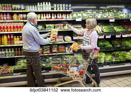 "Senior couple shopping with a shopping trolley in front of a shelf with refrigerated vegetables in a supermarket, Germany, Europe" View Large Photo Image Stock Image - "Senior couple shopping with a shopping trolley in front of a shelf with refrigerated vegetables in a supermarket, Germany, Europe". Fotosearch