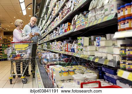 "Senior couple shopping with a shopping trolley in the refrigerated dairy section in a supermarket, Germany, Europe" View Large Photo Image Stock Image - "Senior couple shopping with a shopping trolley in the refrigerated dairy section in a supermarket, Germany, Europe". Fotosearch